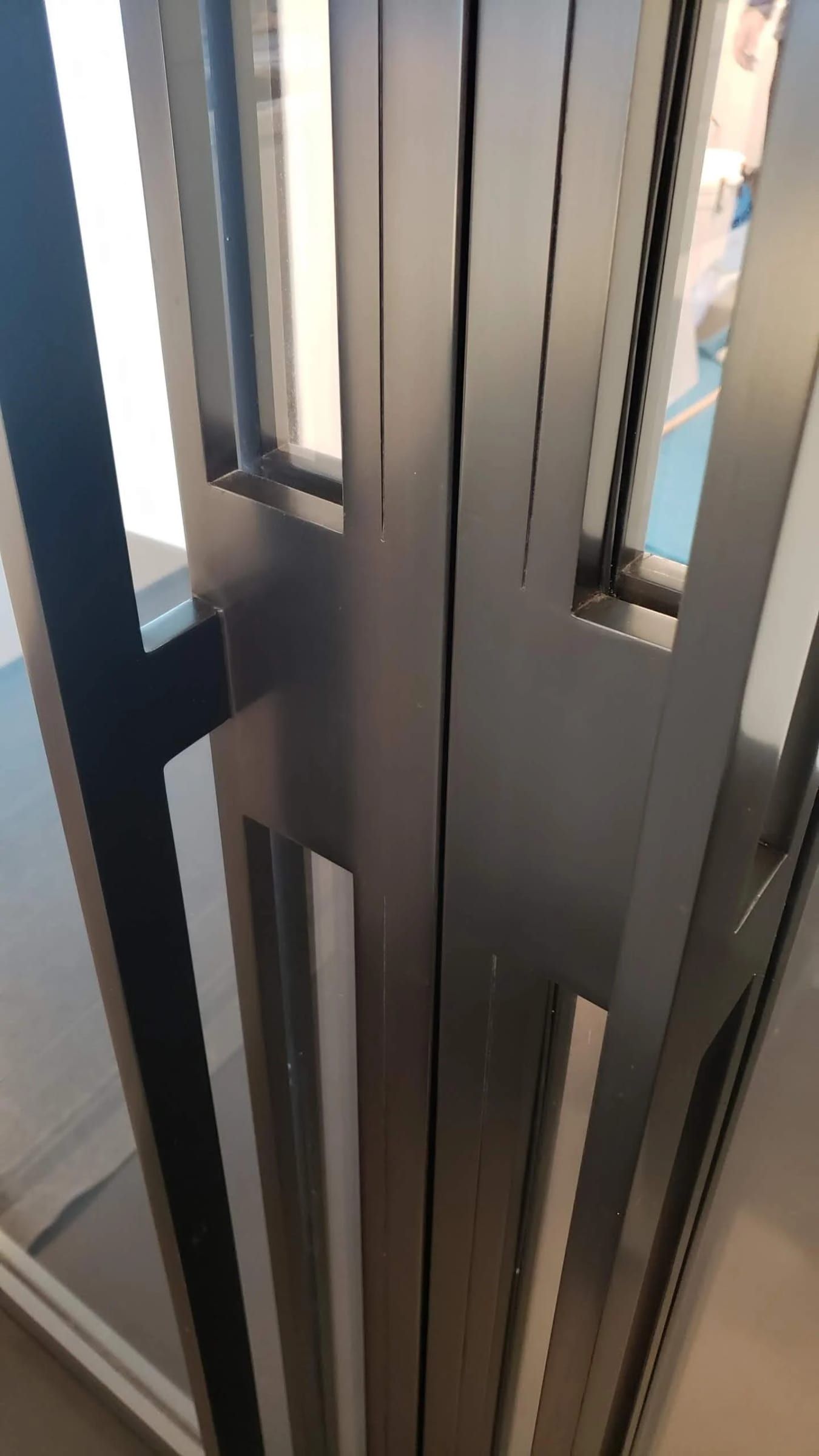 Edge of a blackened stainless door, close detail