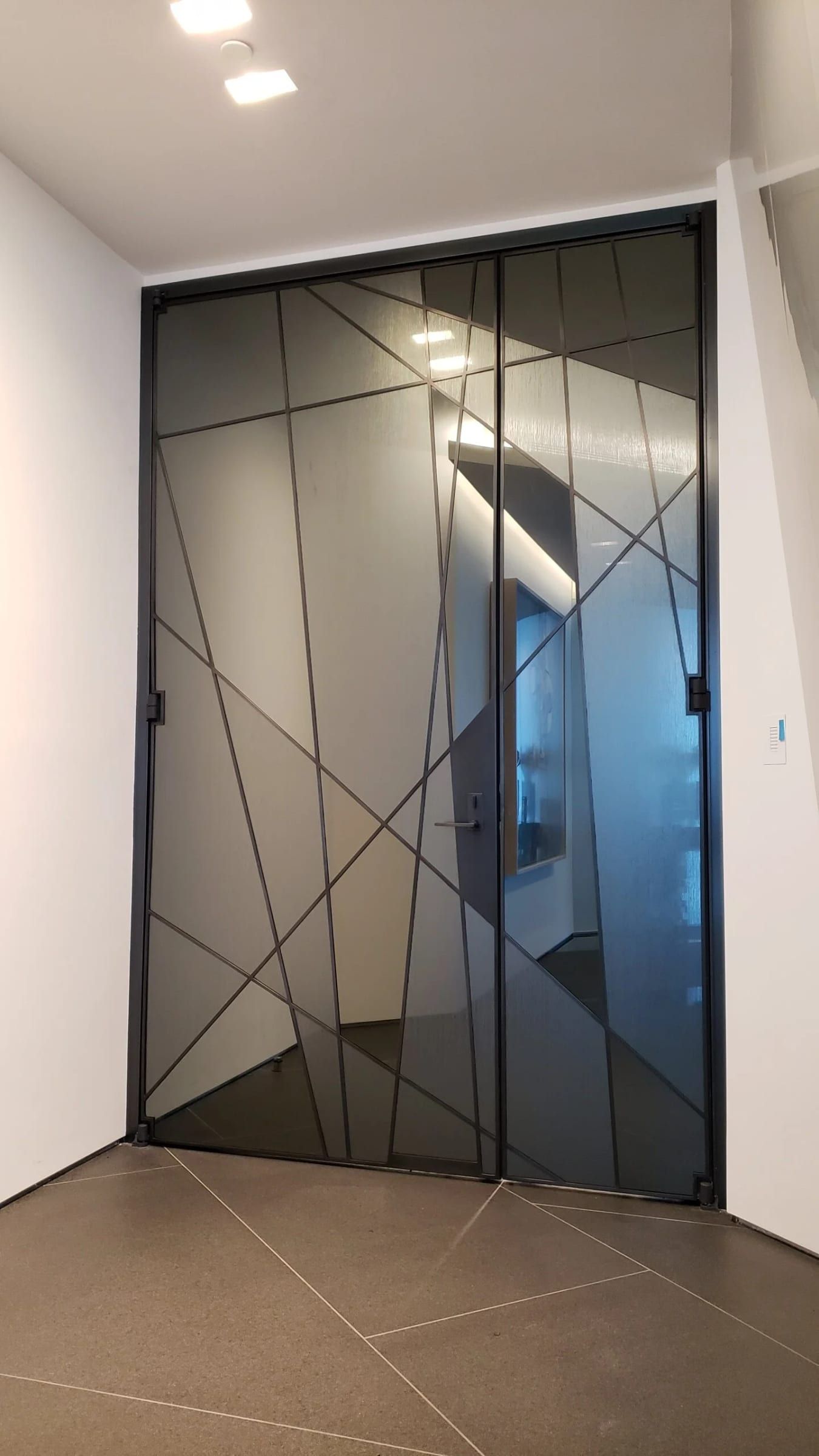Double doors with angled blackened stainless mullions