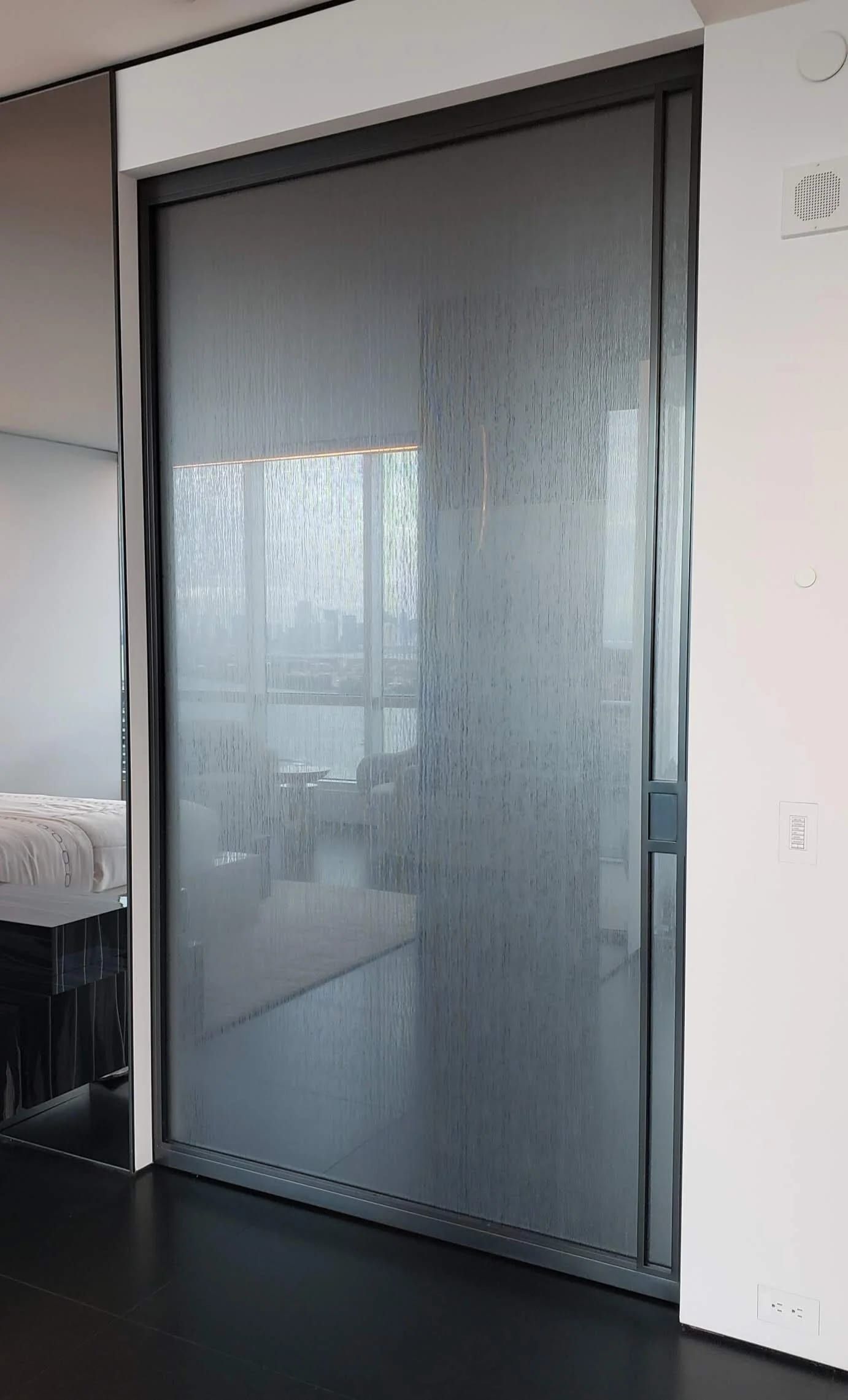 Tall frosted-glass door in a blackened stainless frame