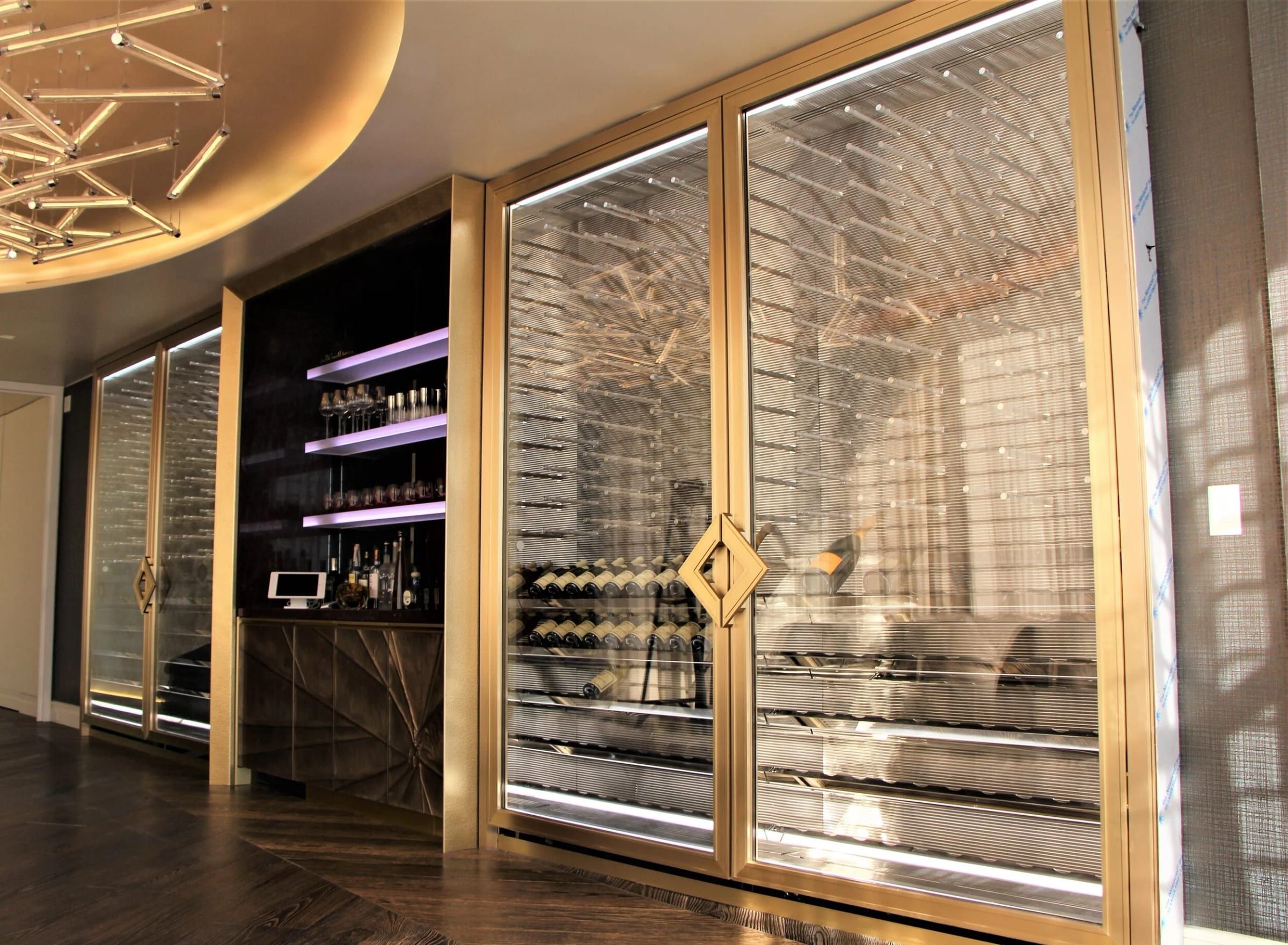 Brass-framed glass doors with a diamond inlay across a wine display