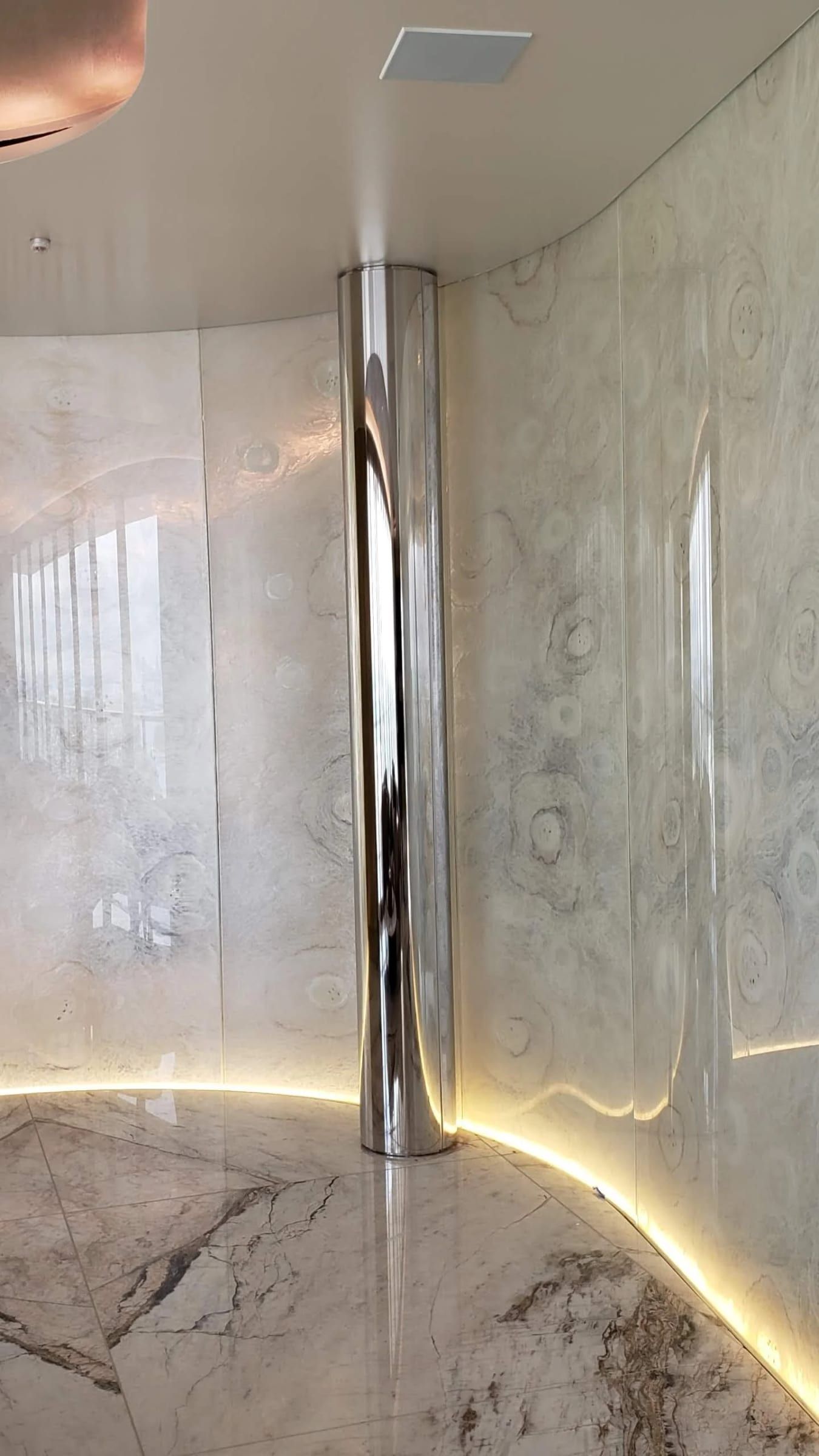 Curved stone wall with a polished metal edge and cove lighting