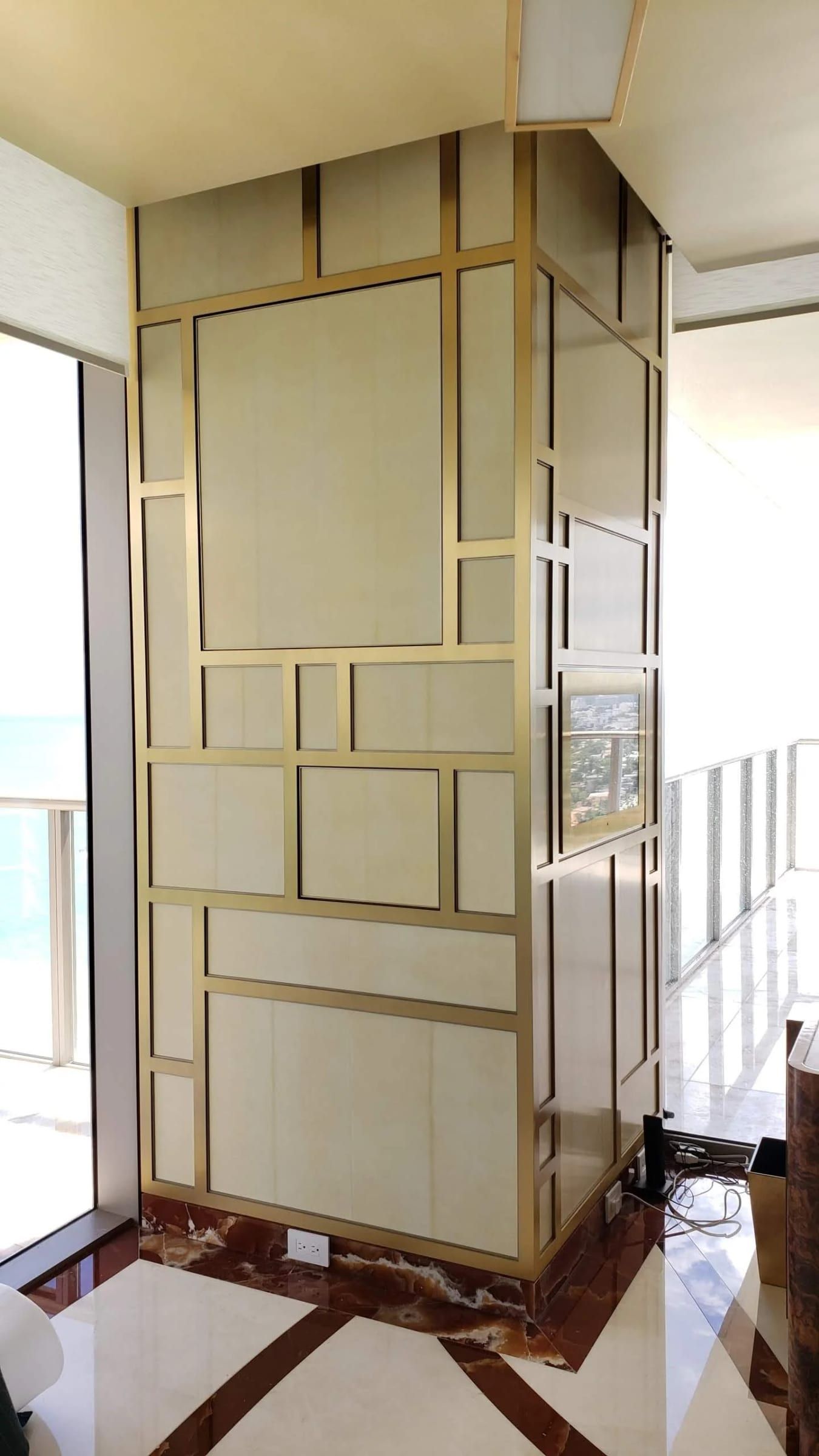 Column clad in brass-framed panels