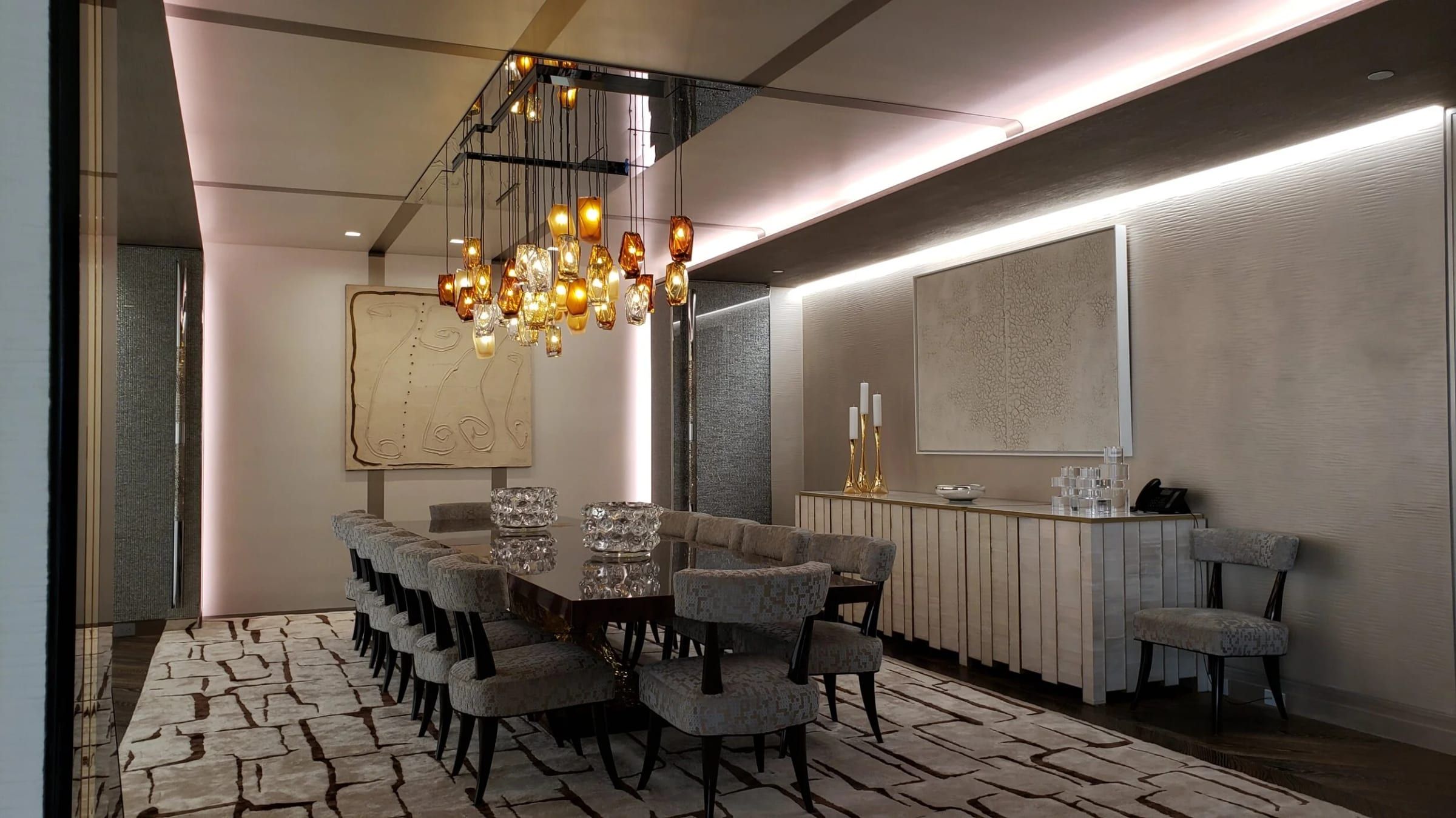 Dining room with brass-trimmed wall panels under a chandelier