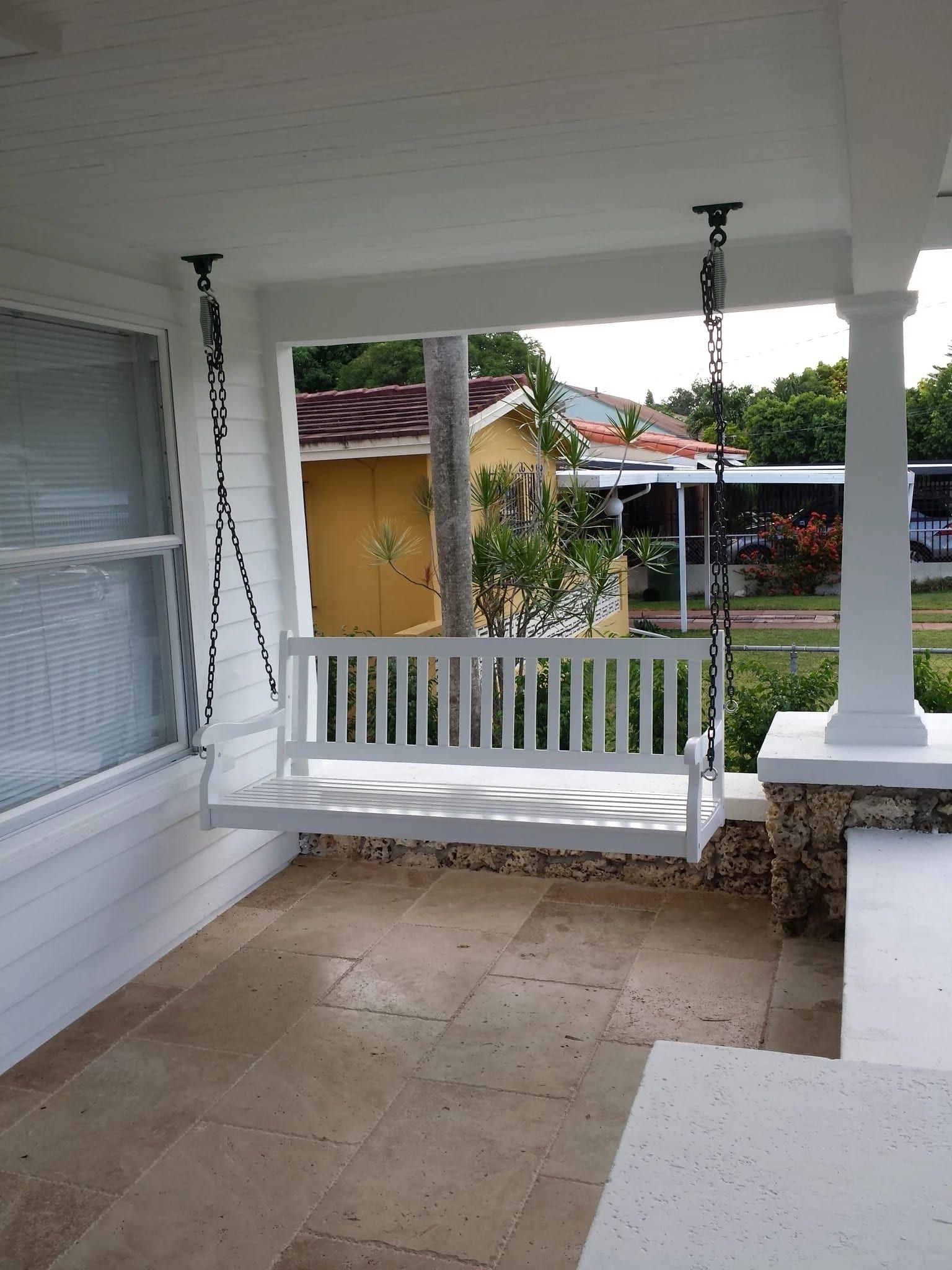Covered porch with a hanging white swing